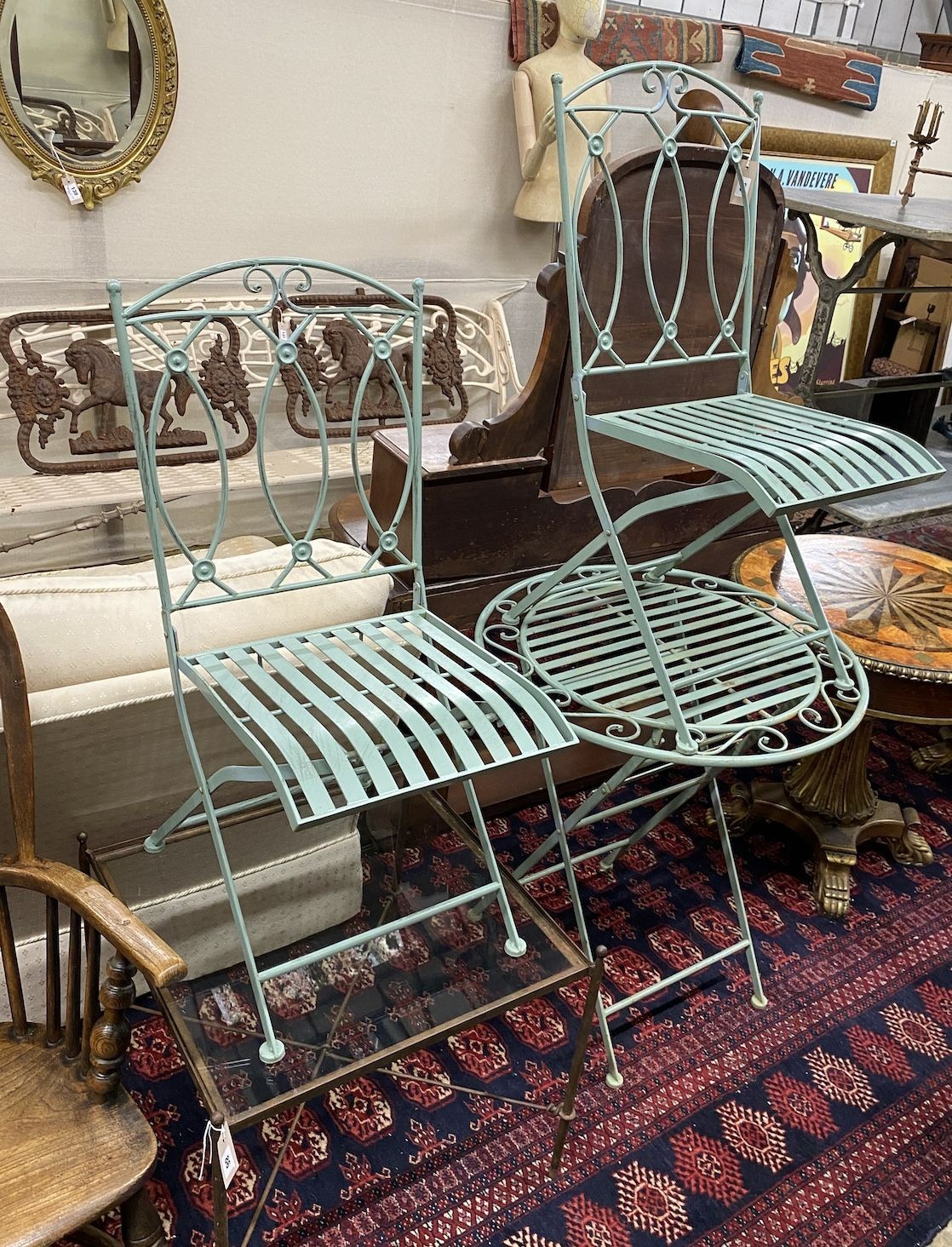 A circular painted metal folding garden table, diameter 70cm, height 76cm and two chairs
